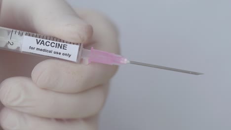 A-Doctor-Push-The-Plunger-Of-Injection-With-Vaccine,-Close-Up-Shot