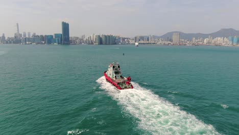 Small-Offshore-supply-ship-roaring-across-Hong-Kong-bay,-Aerial-view
