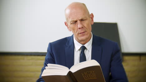 Un-Hombre-De-Negocios-Profesional-Está-Leyendo-La-Sagrada-Biblia-En-Casa