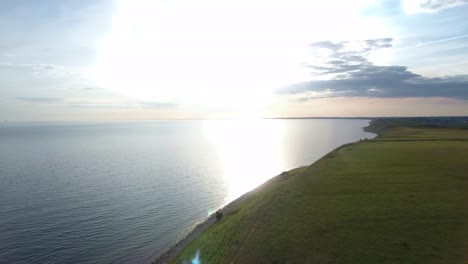 The-Baltic-Sea-From-The-Steep-Hill-of-Ales-Stenar-By-Sunset-in-South-Sweden-Skåne-Kåseberga,-Aerial-Forward-Slow