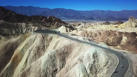 People-Walking-To-The-Lookout-Over-Zabriskie-Point-In-Death-Valley-National-Park,-Aerial-Flyover