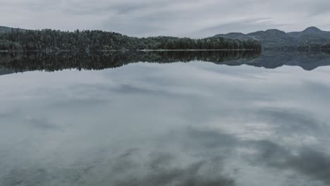 Calm-mountain-lake-and-reflection-of-the-clouds-moving-over-the-lake