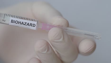 Hand-Attaching-And-Removing-Needle-Of-Syringe---Biohazard-Vaccine---close-up