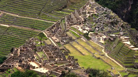 Top-View-Of-The-Ancient-Inca-City-Ruins-Of-Machu-Picchu-Nestled-On-A-Mountain-Ridge-In-Peru---Aerial-Shot