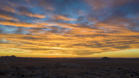 The-desert-sky-cloudscape-is-illuminated-by-the-setting-sun-with-brilliant-colors---aerial-hyperlapse
