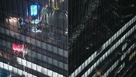 Reflection-On-Glass-Exterior-Of-An-Office-Building-In-Shibuya,-Tokyo-At-Night---Real-Time---high-angle-close-up