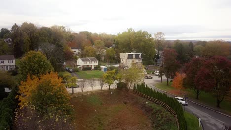 Aerial-push-in-to-a-busy-street-in-Lafayette-Hill,-Pennsylvania-in-the-fall