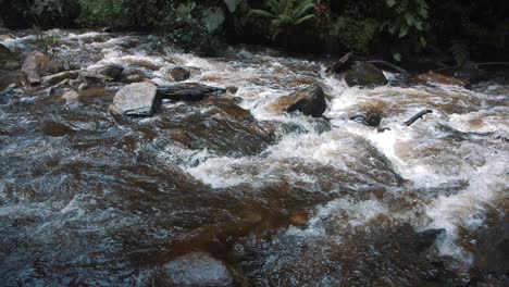 Nahaufnahme-Des-Wassers,-Das-Durch-Einen-Fluss-Mit-Felsen-In-Zeitlupe-Im-Cocora-Tal,-Kolumbien-Fließt
