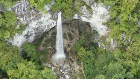 High-view-of-Wildenstein-Waterfall-in-the-southern-Austrian-Alps-over-rocky-mountain-arch,-Aerial-top-exit-dolly-shot