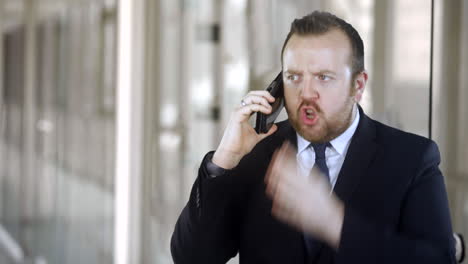 An-angry-businessman-is-talking-on-the-phone