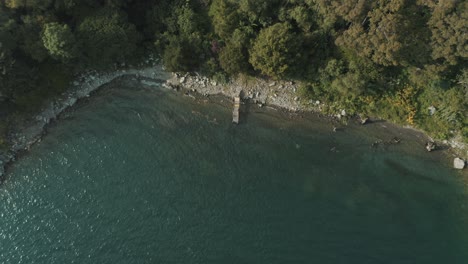 Drone-aerial-top-view-of-waves-crashing-on-the-shore,-dock-of-lake-Atitlan,-Guatemala