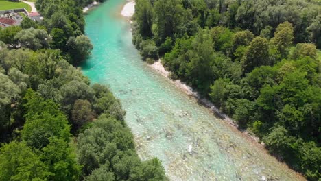 Idyllic-turquoise-fresh-flowing-river-among-lush-forest-greenery-aerial-pull-back-view