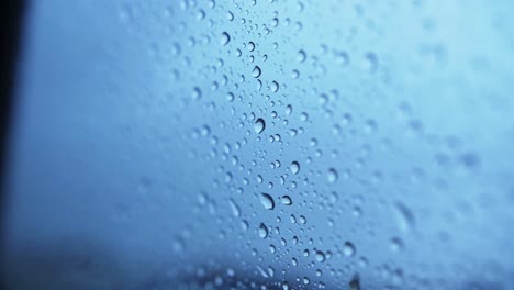 Detailed-shot-of-waterdrops-sticking-on-outside-of-glass-window-of-car
