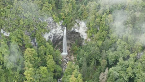 Cascada-Wildenstein-Con-Nubes-Bajas-Y-Brumosas-En-Los-Alpes-Austriacos-Del-Sur,-Toma-Aérea-Amplia