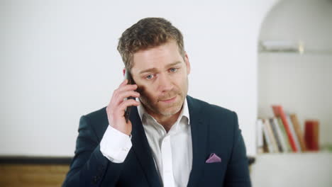 A-frustrated-young-businessman-is-talking-his-phone