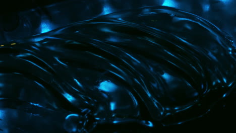 Oil-with-waves-on-surface,-blowing-air,-extreme-closeup-abstract-view
