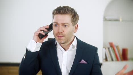 Handsome-young-businessman-is-shouting-instructions-on-his-phone