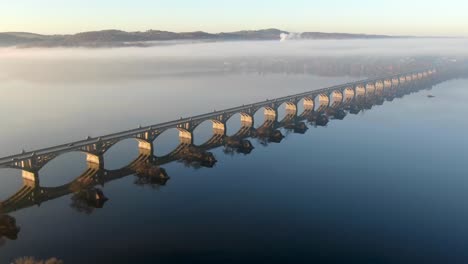 Aerial-of-Susquehanna-River-bridge-between-Lancaster-County-and-York,-PA,-USA-during-morning-fog-and-light