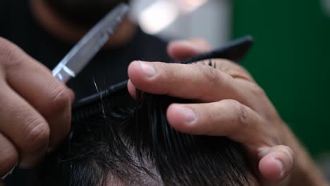Slow-motion-close-up-as-a-barber-styles-and-cuts-a-man's-hair
