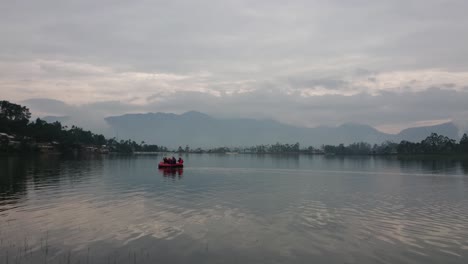 The-crew-is-equipped-on-a-inflatable-rafting-rubber-boat-on-lake-water-surface-at-morning-with-beautiful-view-of-nature-around-the-lake