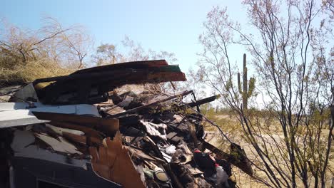 Pan-across-abandoned-trash-trailer-Saugro-cactus-in-the-background,-Scottsdale,-Arizona