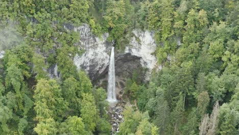 Slow-Approach-to-Wildenstein-Waterfall-in-southern-Austrian-alps-with-dense-forest,-Aerial-dolly-in-reveal-shot