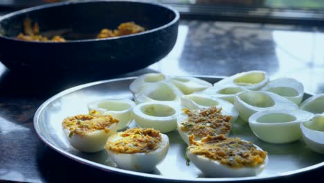 filling-eggs-stuffing-boiled-egg-plate-full-of-Deviled-egg-also-known-as-stuffed-eggs,-Russian-eggs,-or-dressed-eggs