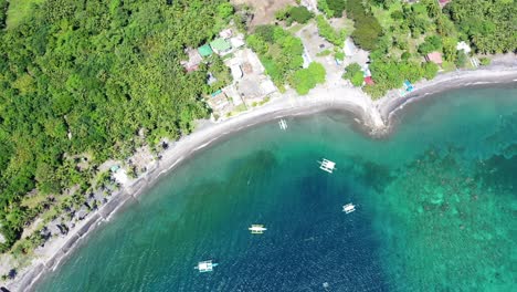 Luftbild-Von-Oben-Nach-Unten-Auf-Eine-Küste-Auf-Den-Philippinen-Mit-Türkisfarbenem-Wasser-Und-Darauf-Schwimmenden-Weißen-Holzbooten,-Reisekonzept