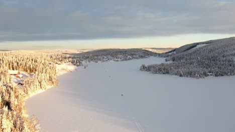 Hermoso-Lago-Congelado-Con-Esquiadores-Y-Montañas-Al-Atardecer-En-Noruega