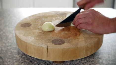 A-chef-is-chopping-onions-in-a-kitchen-on-a-chopping-board-with-a-knife