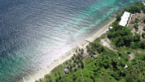 Luftaufnahme-Aus-Der-Vogelperspektive-über-Die-Küste-Eines-Tropischen-Strandes-Mit-Palmen-Und-Einem-Wunderschönen-Korallenriff,-Weitschuss,-Reisekonzept