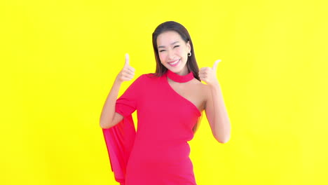 A-smiling,-attractive-young-woman-in-a-red-dress-gives-the-thumbs-up-and-the-ok-hand-gesture