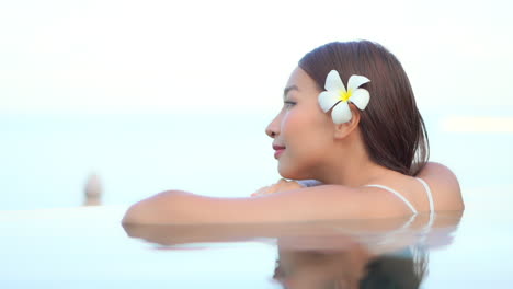Beautiful-Asian-Woman-Daydreaming-at-the-Side-of-the-Swimming-Pool