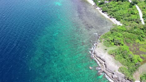Aerial-view-over-a-beautiful-tropical-rocky-coastline-in-Philippines,-drone-flying-above-the-coral-reef-and-turquoise-sea,-travel-concept