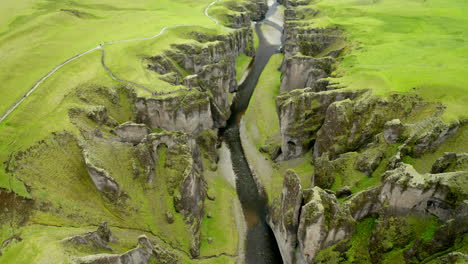 Drone-aerial-footage-flying-through-Fjaðrárgljúfur-canyon-with-huge-100m-sheer-wall-in-south-Iceland