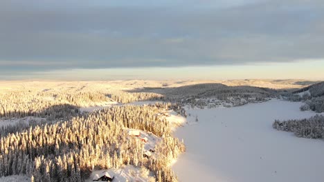 Vista-Aérea-De-Montañas-Invernales-Y-Lagos-Congelados-En-Noruega-Con-Una-Puesta-De-Sol-Dorada