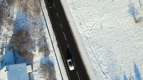 Autos,-Die-An-Einem-Sonnigen-Wintertag-Auf-Einer-Malerischen-Asphaltstraße-Mit-Verschneiter-Landschaft-In-Danzig,-Polen-Fahren