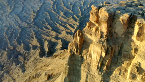 Drone-footage-flying-over-Factory-butte-with-crazy-rock-formations,-textures-and-moonscape-at-golden-hour-in-Utah