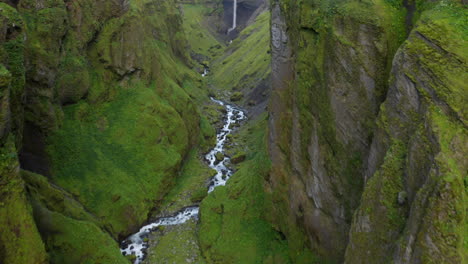 Smooth-Drone-footage-flying-through-deep-Icelandic-Mulagljufur-canyon,-with-dramatic-Hangandifoss-waterfall-at-the-end-of-the-canyon,-in-Southern-Region,-Iceland