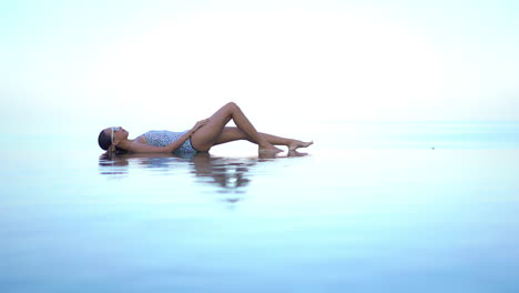 Sensual-Woman-Lying-on-Infinity-Pool-With-Isolated-Background