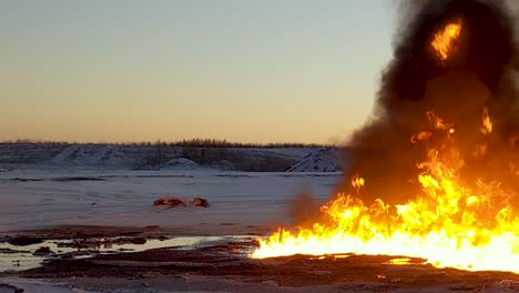 Pan-right-shot-of-huge-oil-spill-burning-in-the-snow