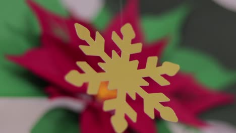 Christmas-decoration.-Poinsettia-and-golden-snowflake.-Blurred-background