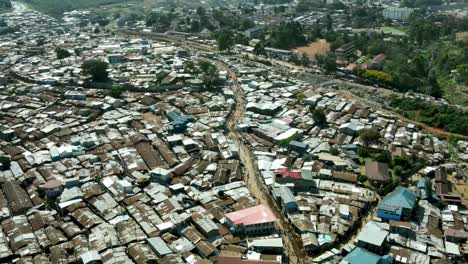 Aerial-backward-shot-of-poor-urban-slum-region-named-Kibera-during-hot-summer-day