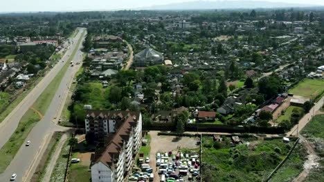 La-Ciudad-De-Nairobi-Con-La-Conducción-De-Automóviles-En-La-Carretera-Y-Los-árboles-Y-Campos-Verdes-Del-Bosque-Durante-El-Día-Soleado
