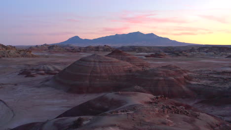 Drone-Volando-Más-Allá-Del-Hombre-En-Formaciones-Rocosas-De-Colores-En-La-Estación-De-Investigación-Del-Desierto-De-Marte-En-Utah,-Estados-Unidos