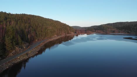 Aerial-View-Of-Lake-Karnsjon-Near-A-Lonely-Road-In-Bohuslan-Sweden,-Rising-Shot
