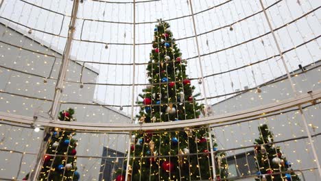 Nahaufnahme-Von-Weihnachtsbäumen-Im-Freien,-Die-Mit-Ornamenten-Und-Blinkenden-Lichtern-Geschmückt-Sind