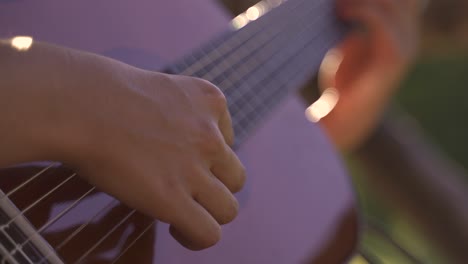 4K-Young-female-kindly-playing-guitar-outdoors-daylight-sunset-closeup