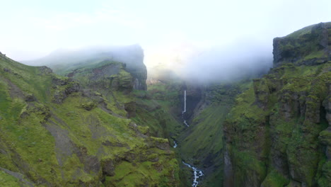 Smooth-Drone-footage-flying-through-deep-Icelandic-Mulagljufur-canyon,-with-dramatic-Hangandifoss-waterfall-at-the-end-of-the-canyon,-in-Southern-Region,-with-rvierIceland