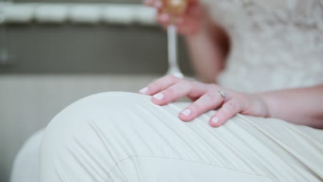 Hand-Der-Braut-Auf-Dem-Schoß-Des-Bräutigams-Am-Hochzeitstag---Selektiver-Fokus